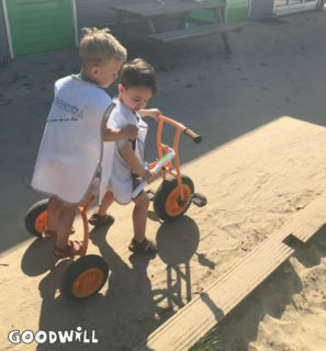 2 kinderen van Youké spelen met de nieuwe driewieler van Goodwill