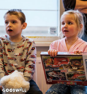 2 kinderen kijken wat er uit het kinderkerstpakket van Goodwill komt