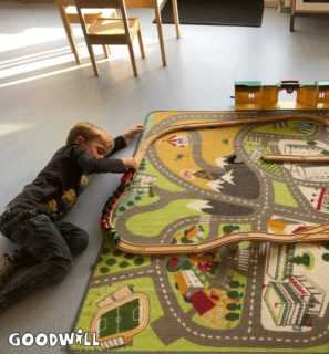 Liggend op de grond met de trein spelen-Goodwill.nl